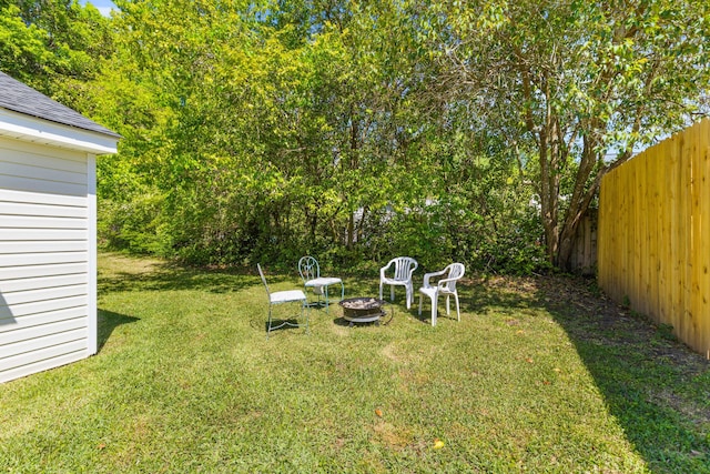 view of yard with an outdoor fire pit and fence