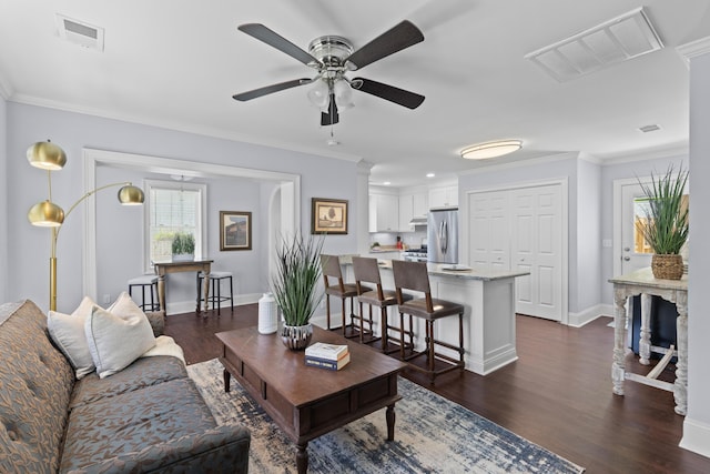 living area with plenty of natural light, a ceiling fan, and visible vents