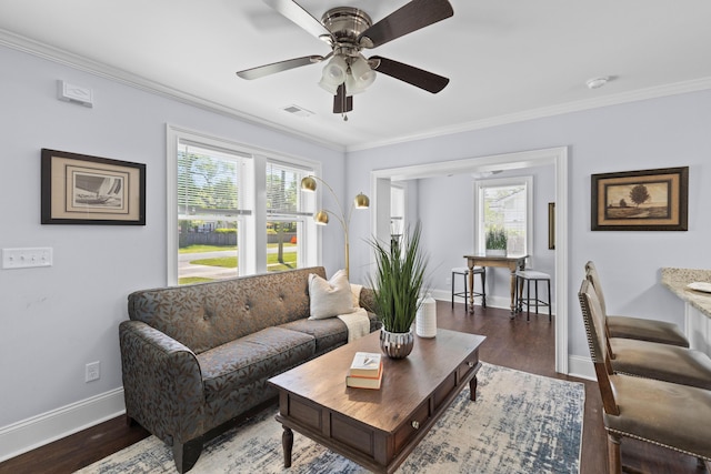 living room with baseboards, crown molding, and plenty of natural light