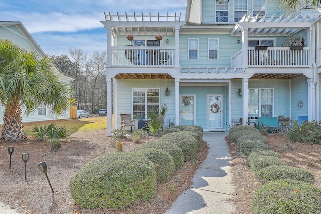 view of front of property featuring a porch, a balcony, and a pergola