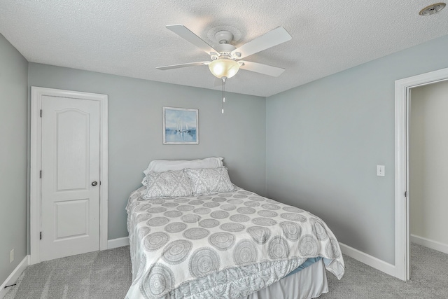 bedroom with a textured ceiling, baseboards, and carpet