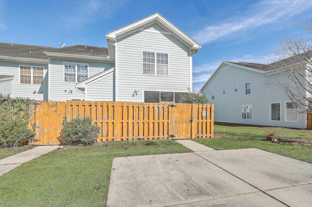 back of house with fence, a lawn, and a patio area