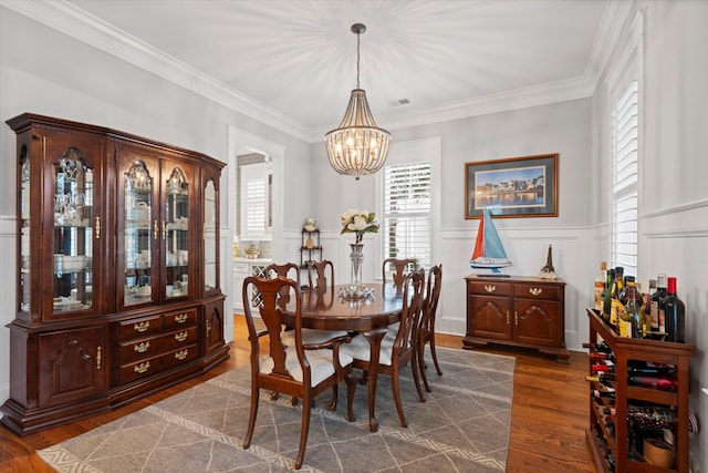 3739 Goodwater St, Mount Pleasant, SC 29466 - dining area featuring a chandelier, a decorative wall, ornamental molding, dark wood-type flooring, and wainscoting