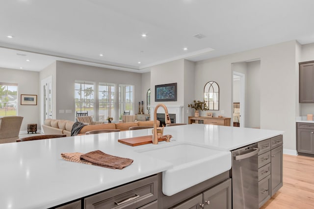 kitchen featuring dishwasher, sink, gray cabinetry, and light hardwood / wood-style floors