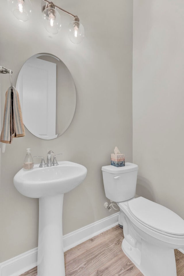 bathroom with toilet, sink, and hardwood / wood-style flooring