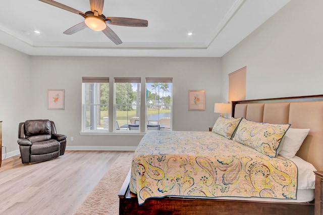 bedroom featuring a tray ceiling, wood-type flooring, and ceiling fan