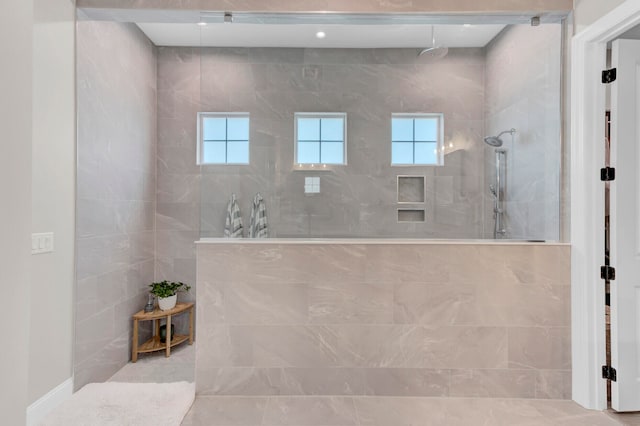 bathroom featuring tiled shower and tile patterned flooring