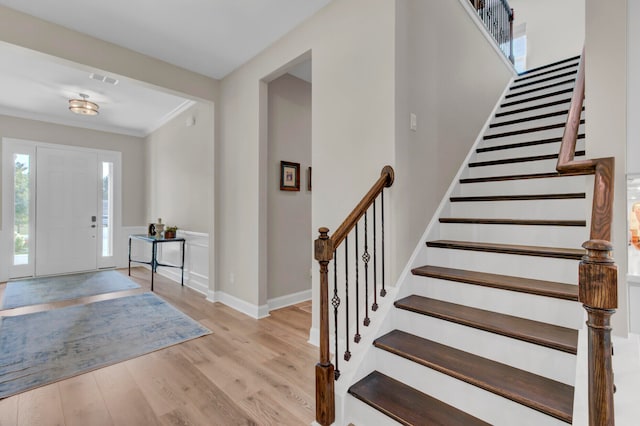 foyer featuring crown molding and light hardwood / wood-style flooring