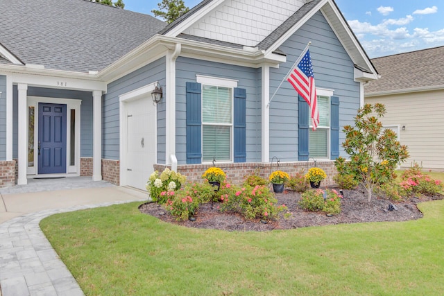 doorway to property with a yard and a garage