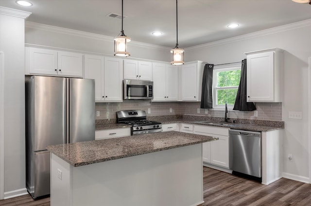 kitchen with a sink, white cabinets, tasteful backsplash, and stainless steel appliances