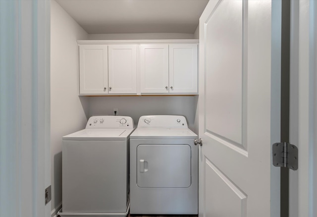 clothes washing area featuring independent washer and dryer and cabinet space