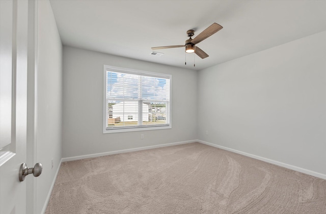 carpeted empty room with a ceiling fan, baseboards, and visible vents