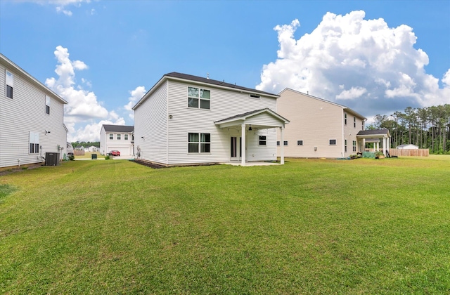 rear view of house with a patio area, central AC, and a yard