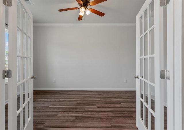 empty room featuring baseboards, dark wood-style floors, french doors, and ornamental molding