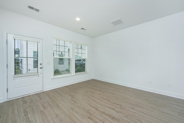 empty room with light wood-style flooring, recessed lighting, baseboards, and visible vents