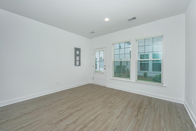 empty room featuring visible vents, baseboards, and wood finished floors