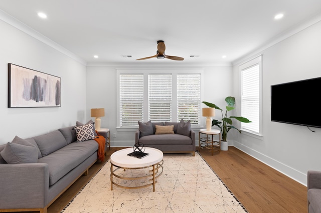 living room featuring light wood-type flooring, ceiling fan, and ornamental molding