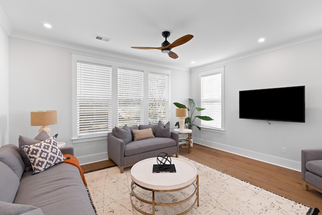 living room with ceiling fan, light hardwood / wood-style floors, and ornamental molding