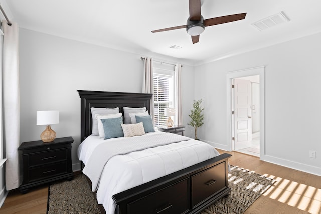 bedroom featuring ceiling fan, ensuite bathroom, and hardwood / wood-style flooring