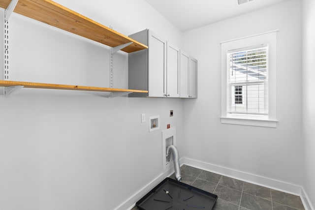 laundry area with electric dryer hookup, cabinets, dark tile patterned floors, and hookup for a washing machine