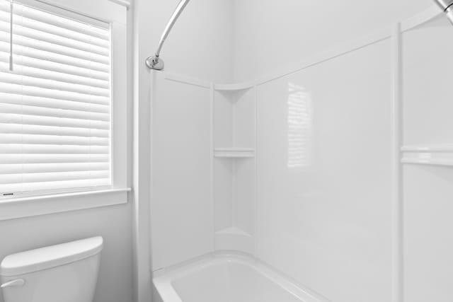 bathroom featuring bathtub / shower combination and toilet