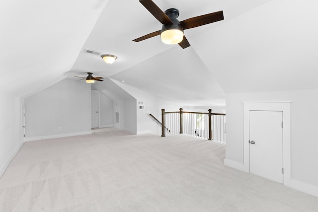 additional living space with ceiling fan, light colored carpet, and vaulted ceiling