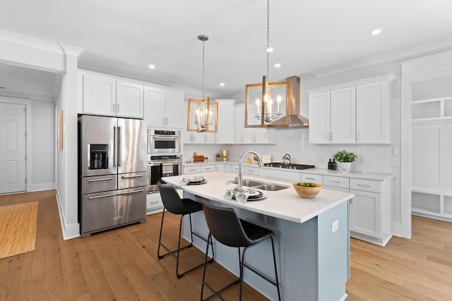 kitchen with white cabinets, pendant lighting, light wood-type flooring, and stainless steel appliances