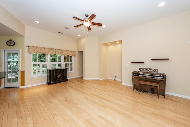living room featuring wood-type flooring, a ceiling fan, recessed lighting, and baseboards