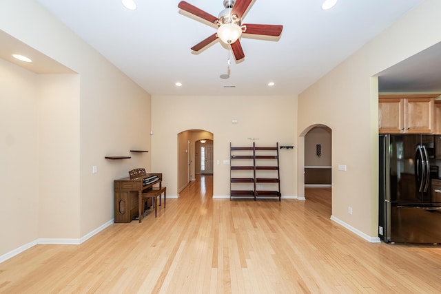living room with arched walkways, a ceiling fan, light wood finished floors, and recessed lighting