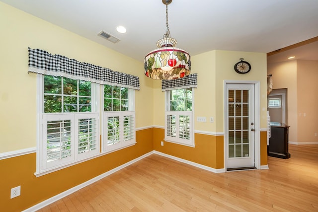 unfurnished dining area with wood finished floors, baseboards, and recessed lighting