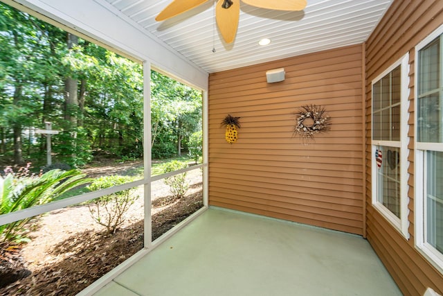 unfurnished sunroom featuring ceiling fan