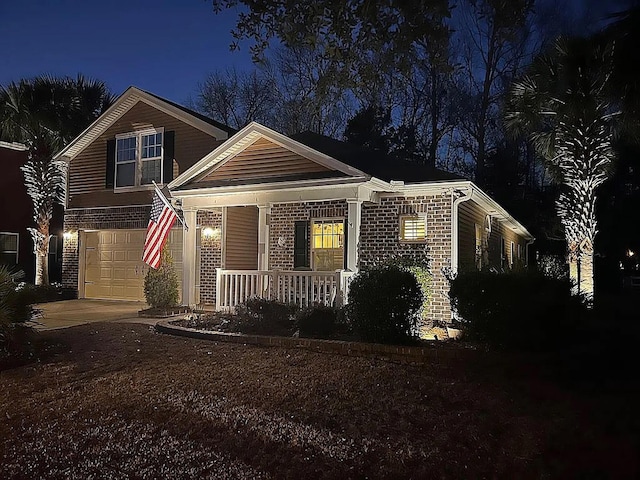 view of front of property featuring covered porch, a garage, concrete driveway, and brick siding