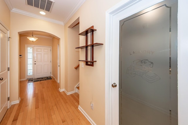 entrance foyer with arched walkways, ornamental molding, light wood-type flooring, baseboards, and recessed lighting