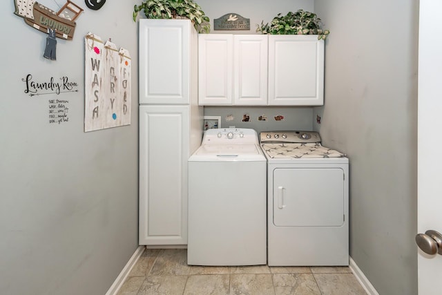 laundry room with cabinet space, washing machine and dryer, baseboards, and light stone finish floors