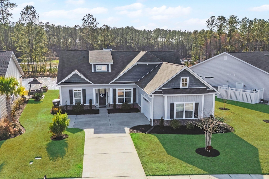 craftsman house with a garage, covered porch, and a front lawn