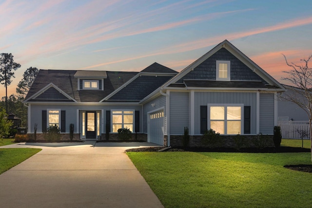 craftsman house featuring a garage and a lawn