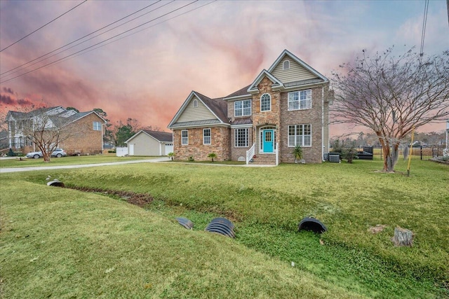 view of front facade with brick siding and a front lawn