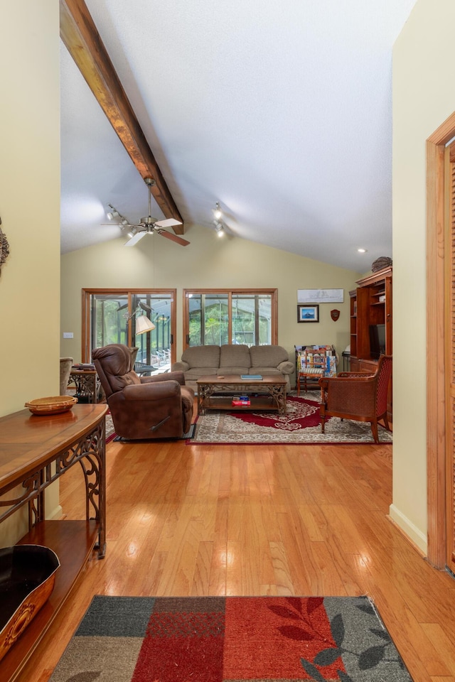 living room with lofted ceiling with beams and light wood-type flooring