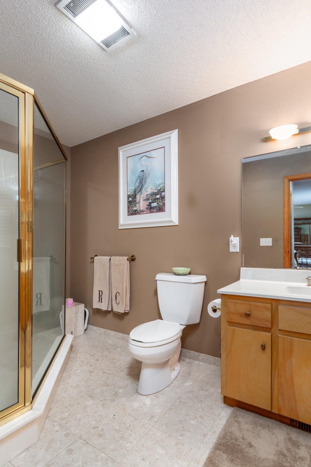 bathroom featuring vanity, toilet, a shower with door, and a textured ceiling