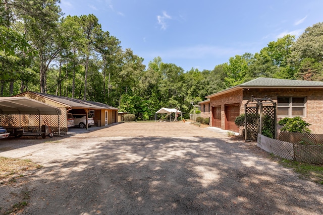 view of side of home featuring a garage and a carport