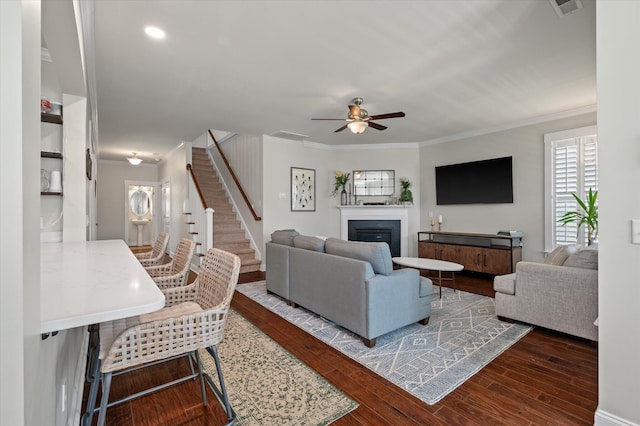 2627 Rutherford Way, Charleston, SC 29414 - living room featuring crown molding, a ceiling fan, stairs, wood finished floors, and a glass covered fireplace