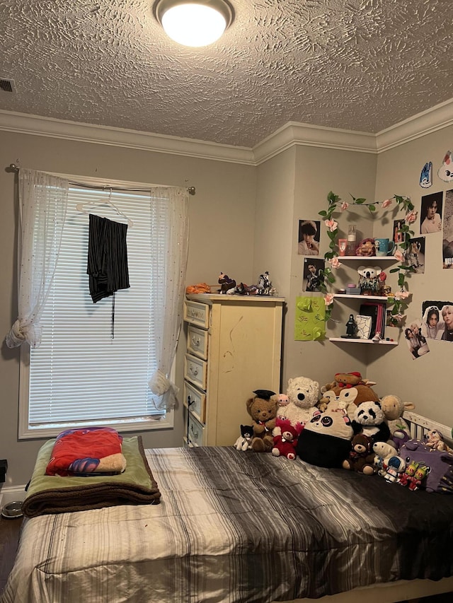 bedroom with a textured ceiling and crown molding