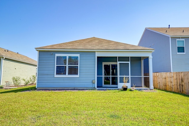 rear view of property featuring a sunroom and a yard