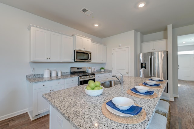 kitchen featuring a center island with sink, white cabinetry, sink, and appliances with stainless steel finishes