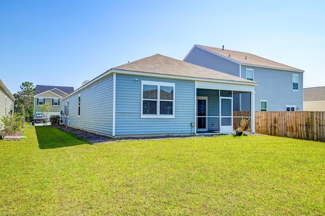 back of house with a lawn and a sunroom