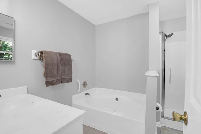 bathroom with tile patterned flooring, a sink, a garden tub, and a stall shower