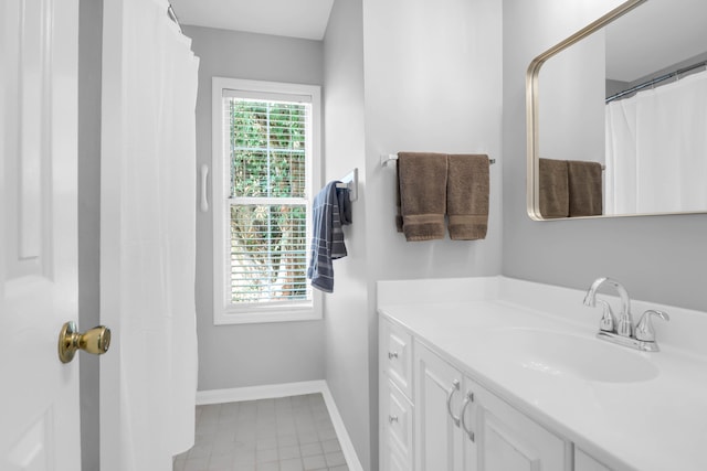 full bath featuring baseboards and vanity