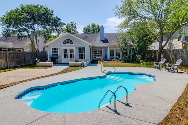 view of swimming pool with a fenced in pool, french doors, and a patio area