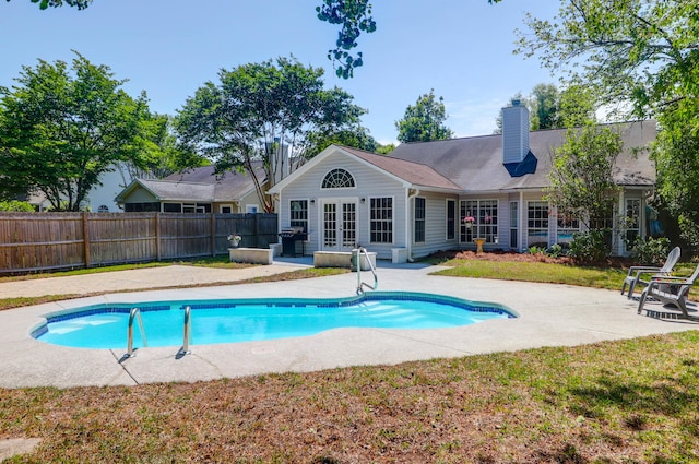 view of pool featuring a fenced in pool, french doors, a fenced backyard, and a patio area