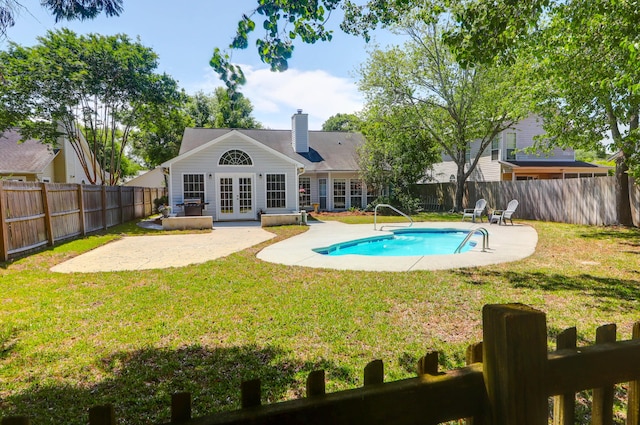 view of swimming pool with a lawn, a patio area, and french doors